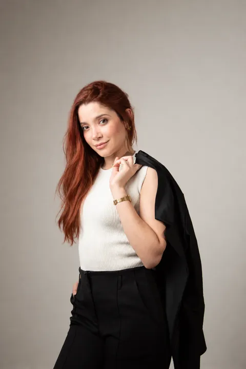 Amanda Tallya de blusa branca com o blazer no ombro